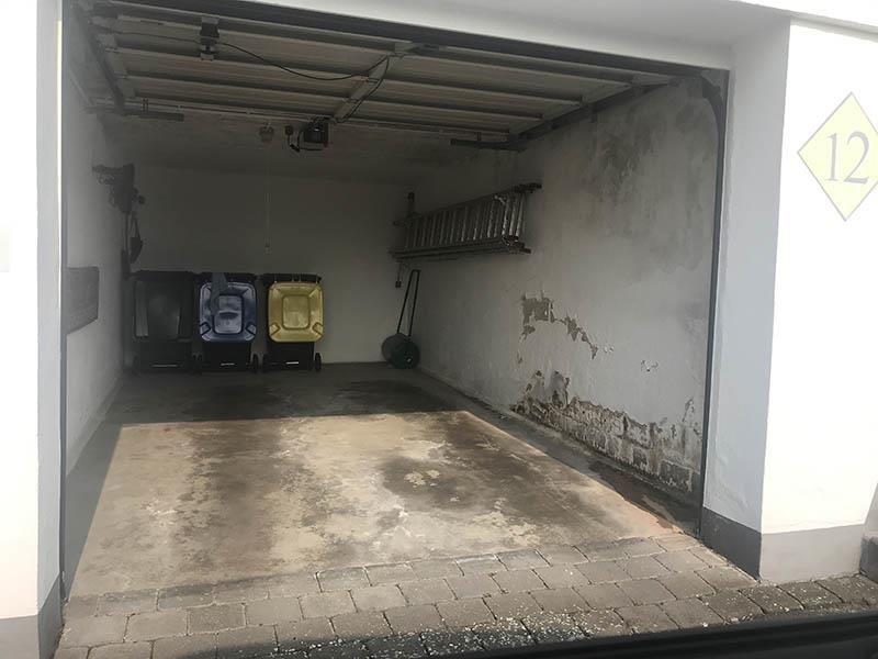 Eine Garage mit einer Leiter und Mülltonnen darin