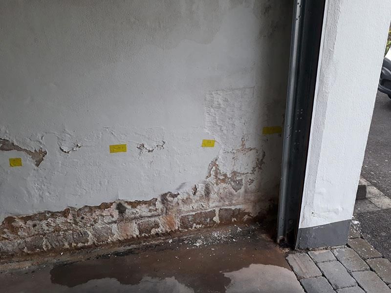 Neben einer Tür befindet sich eine weiße Wand mit gelben Aufklebern.