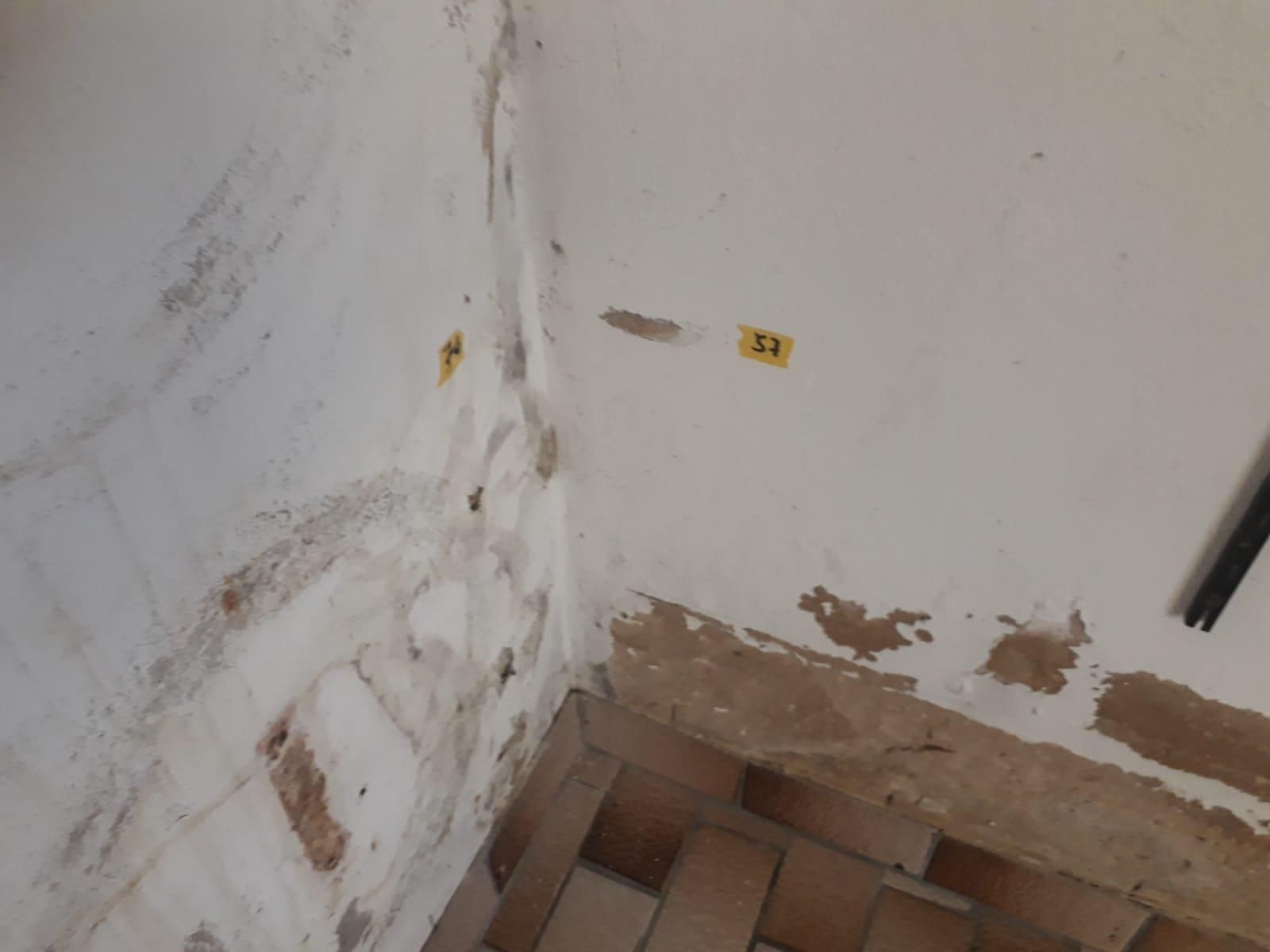 Eine Ecke einer Wand mit einem gelben Schild daran.