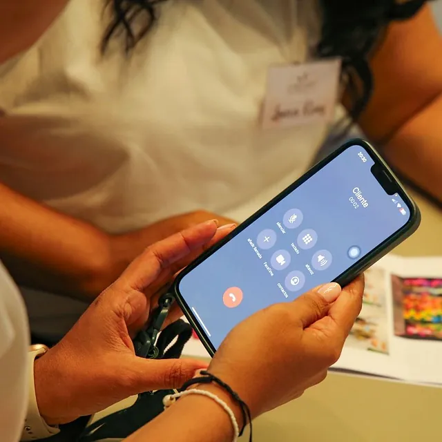 Una persona sostiene un teléfono celular con una llamada en él.