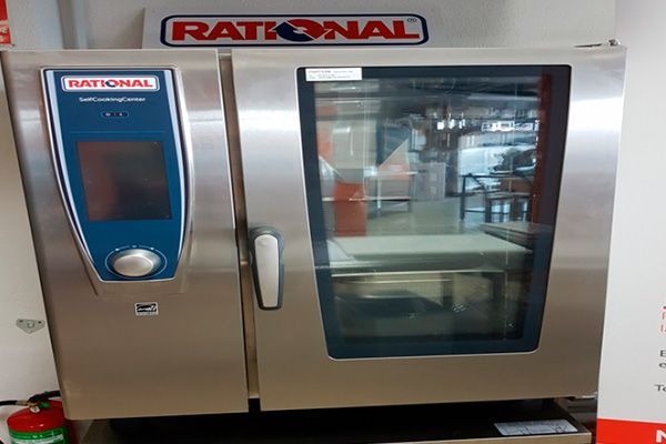 Horno combinado Rational de acero inoxidable con panel de control azul y puerta de cristal.