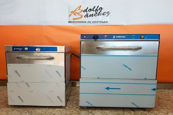 Dos lavavajillas comerciales de acero inoxidable, uno más pequeño que el otro. Ambos tienen detalles azules y película protectora.