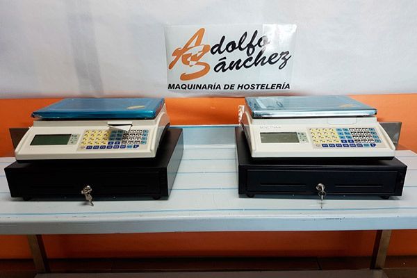 Dos balanzas electrónicas con cajones portamonedas en un estante, logotipo en el fondo.