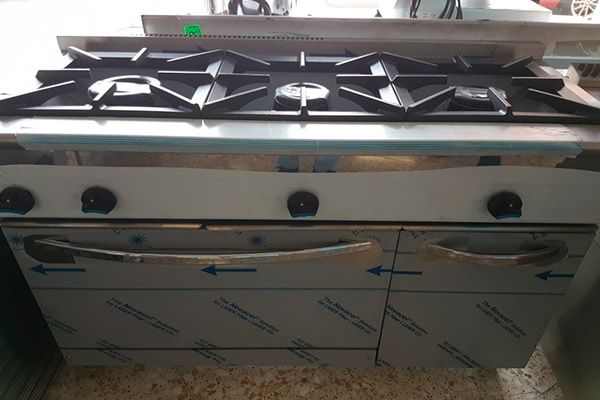Estufa a gas comercial de acero inoxidable con seis quemadores y dos hornos.