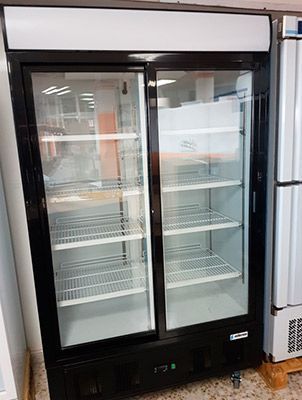 Refrigerador comercial de doble puerta negro con puertas corredizas de vidrio, estantes blancos y pantalla de temperatura.