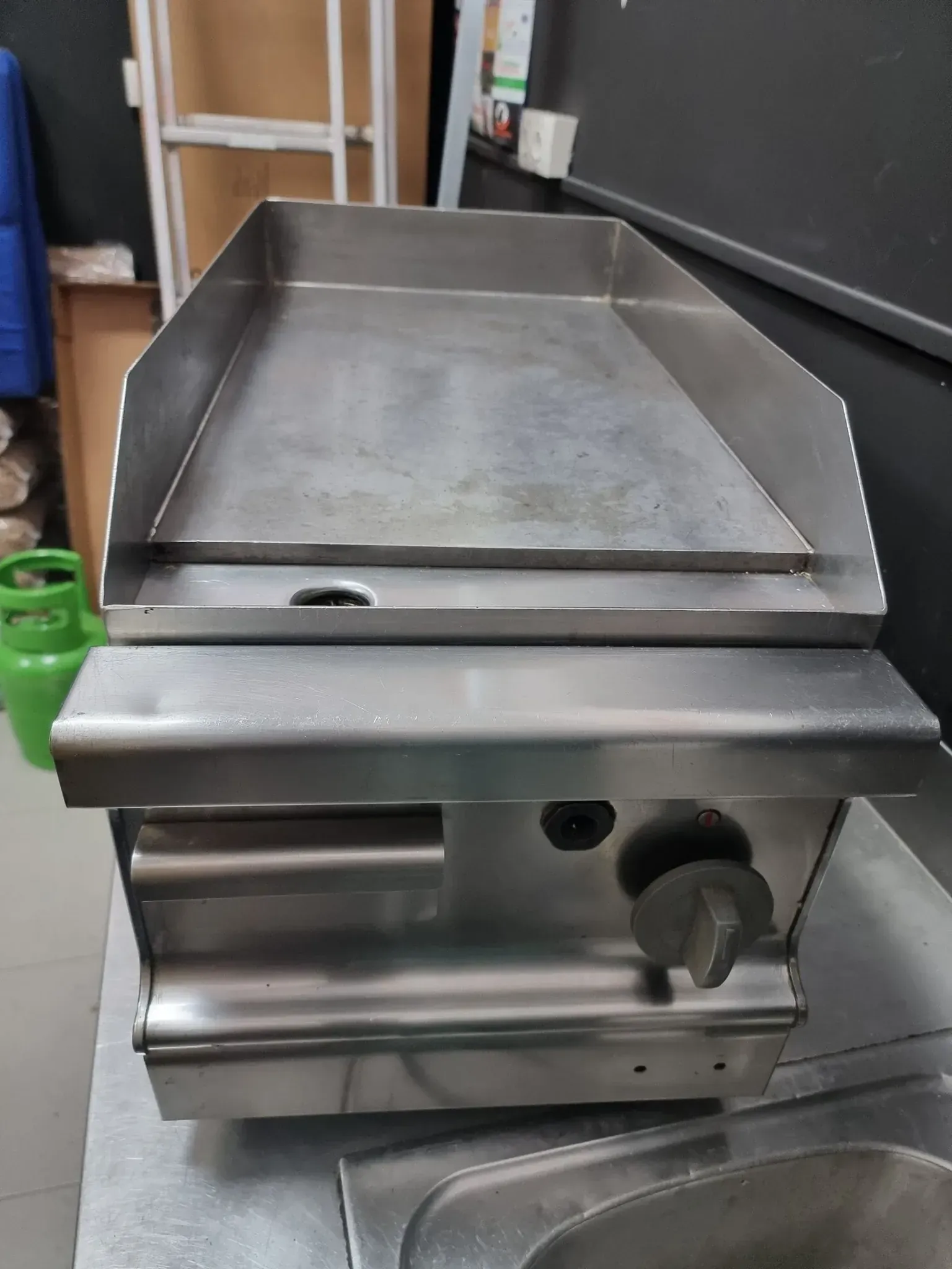 Plancha a gas de acero inoxidable, vista superior, con perilla de control.