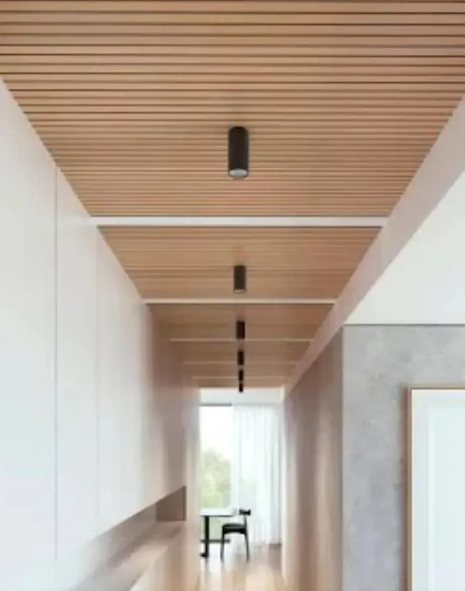 Pasillo moderno con techo de listones de madera, luces empotradas y una ventana luminosa al fondo