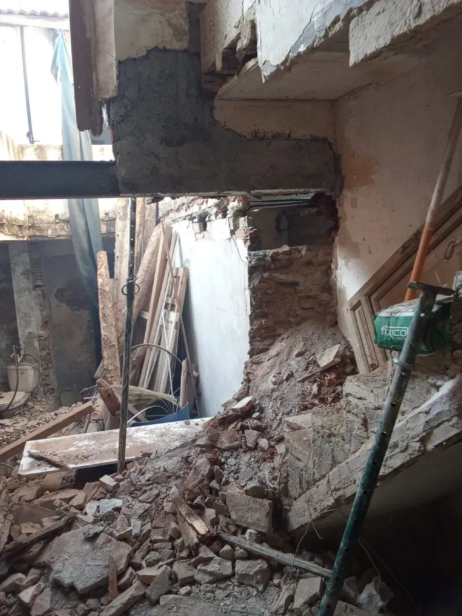 Muro interior derrumbado, con escombros y hormigón roto, en un edificio dañado