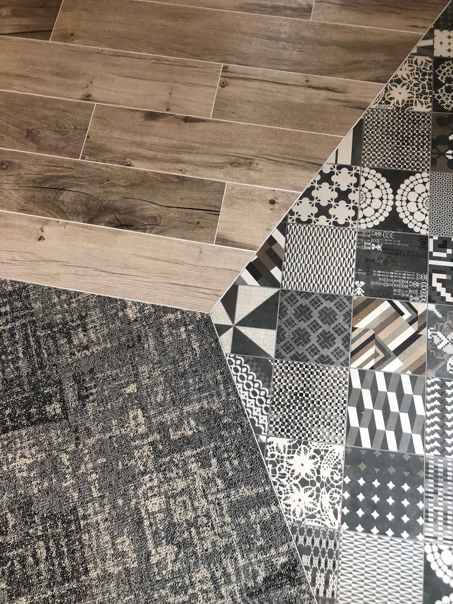 Carrelage imitation bois et carrelage à motifs au sol, avec un tapis recouvrant une partie de la surface.