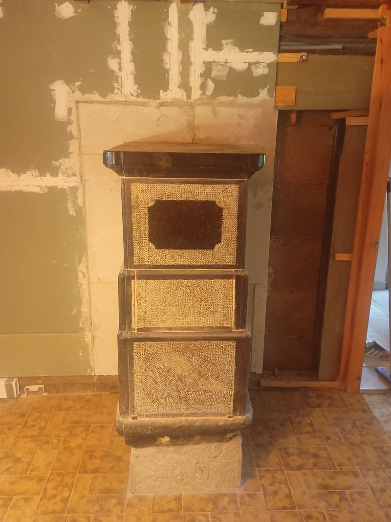 Un poêle à bois se trouve dans une pièce à côté d'une porte.