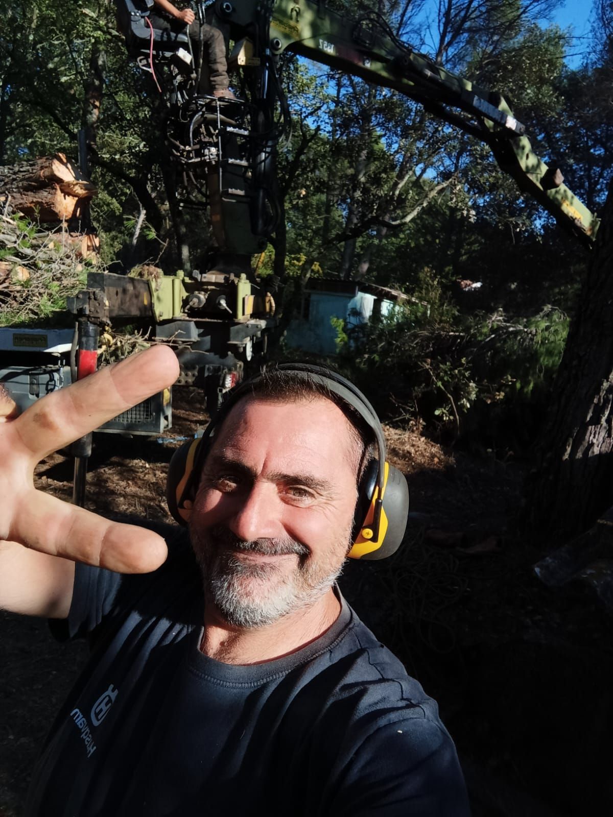 Un homme portant des écouteurs prend un selfie dans les bois.