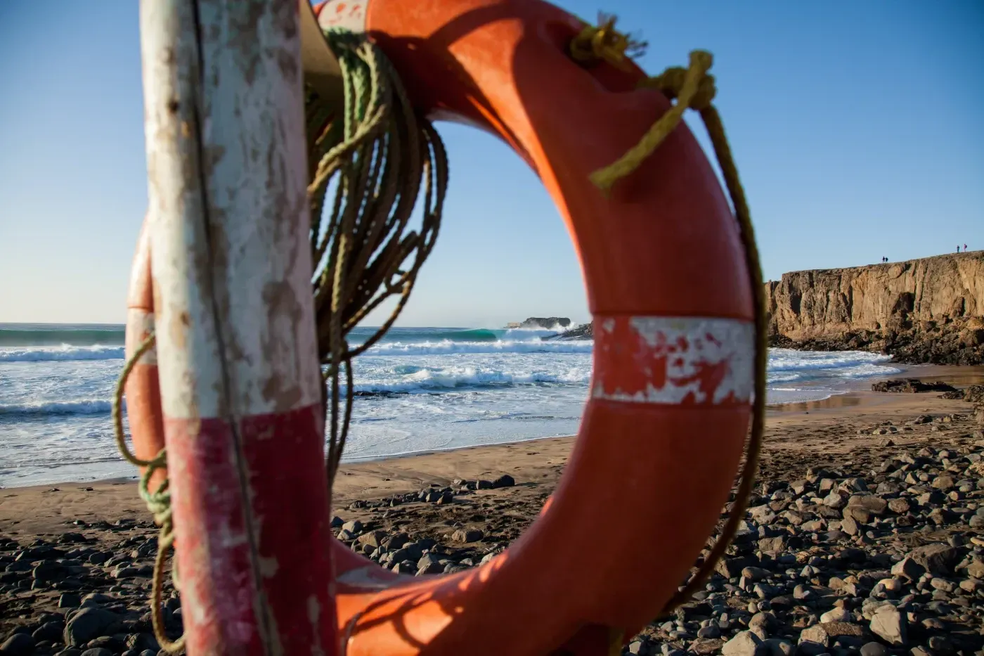 Un salvavidas está atado a un poste en la playa.
