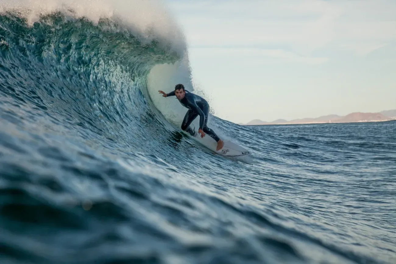 Un hombre está montando una ola en una tabla de surf en el océano.