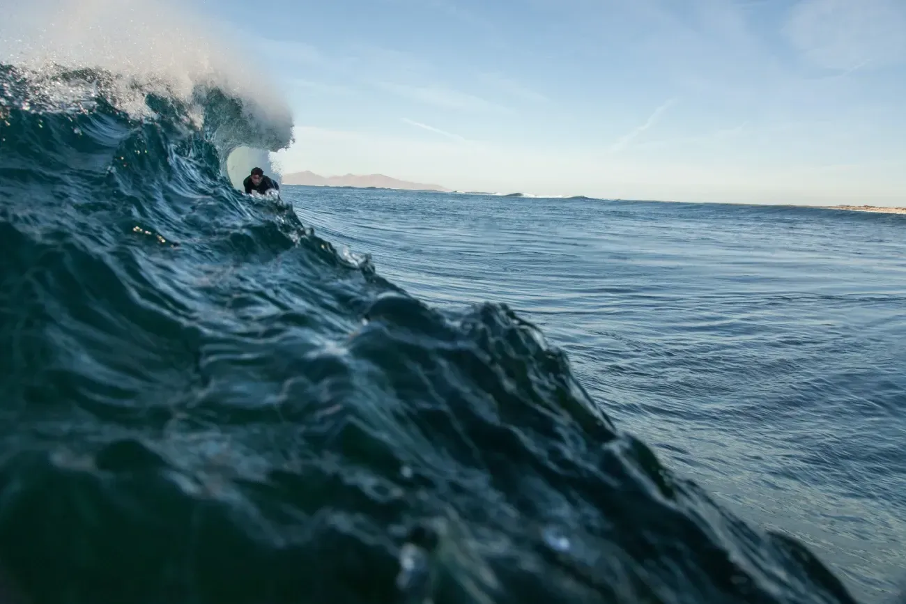 Un surfista está montando una ola en el océano.
