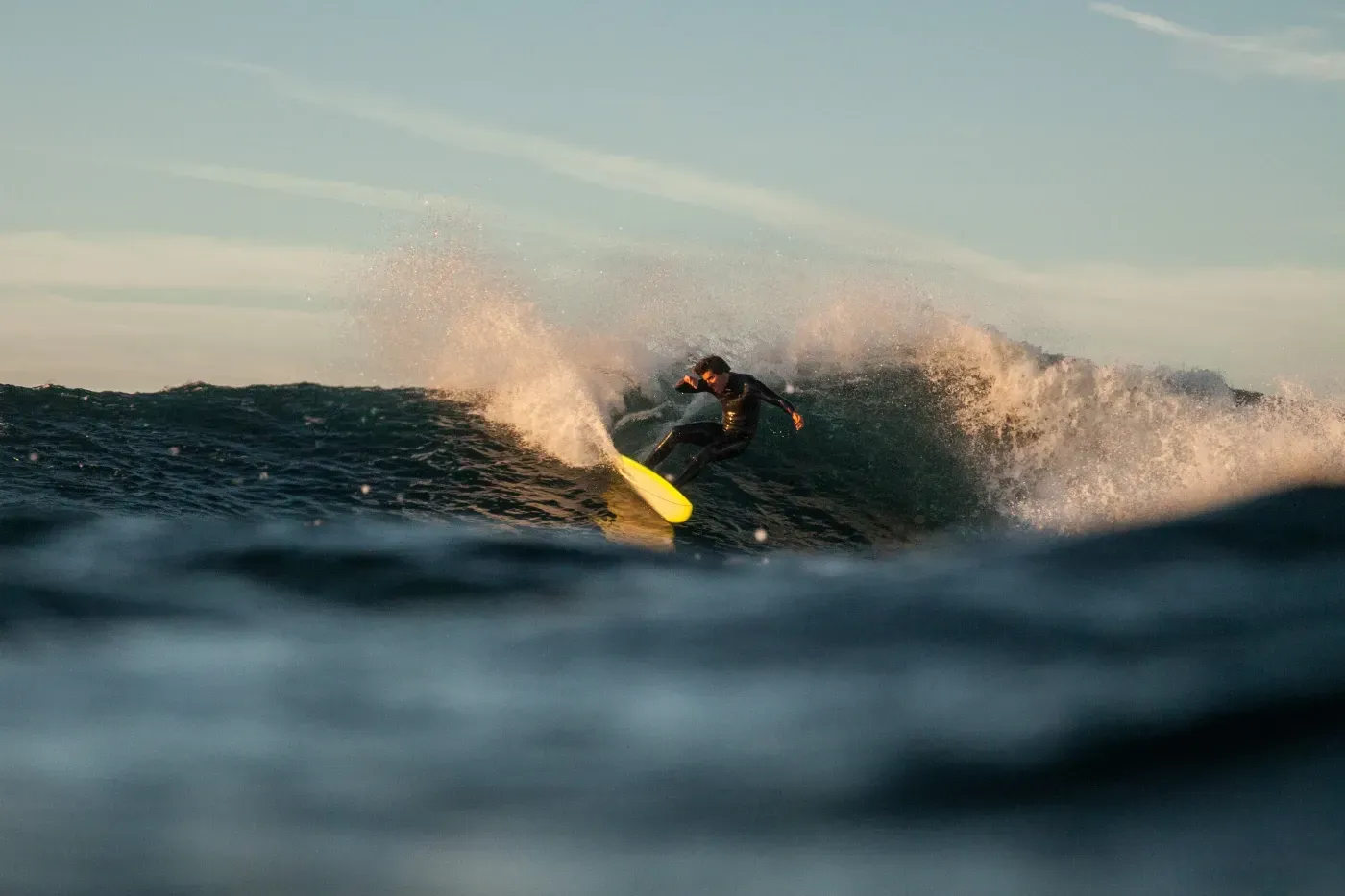 Un hombre está montando una ola en una tabla de surf en el océano.