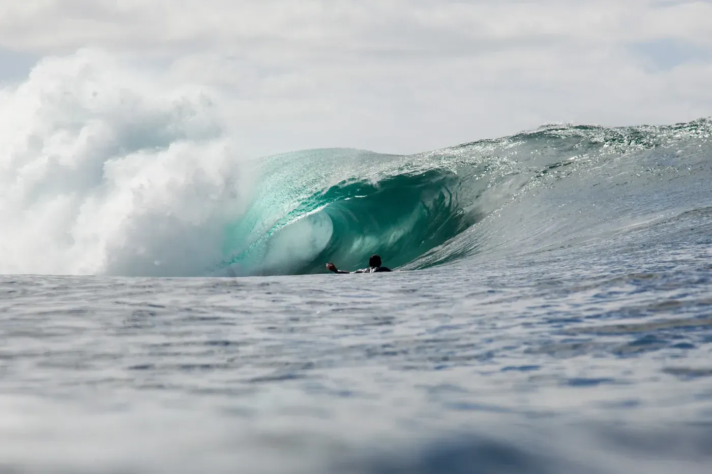 Una persona está montando una ola en el océano.