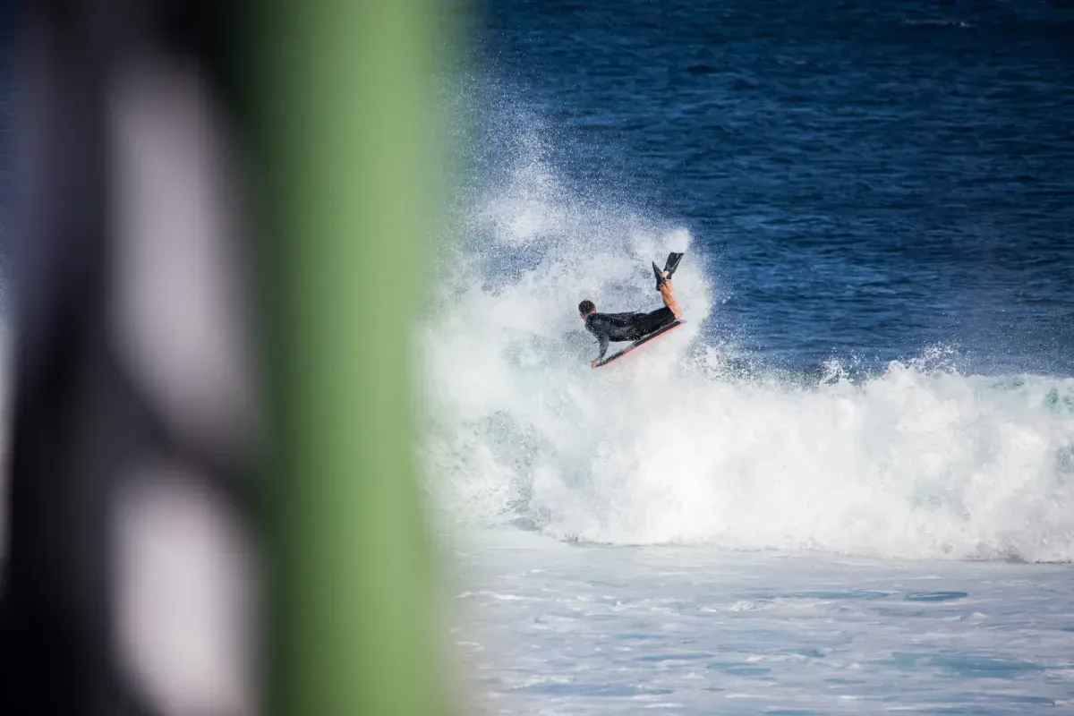 Un hombre está montando una ola en una tabla de surf en el océano.