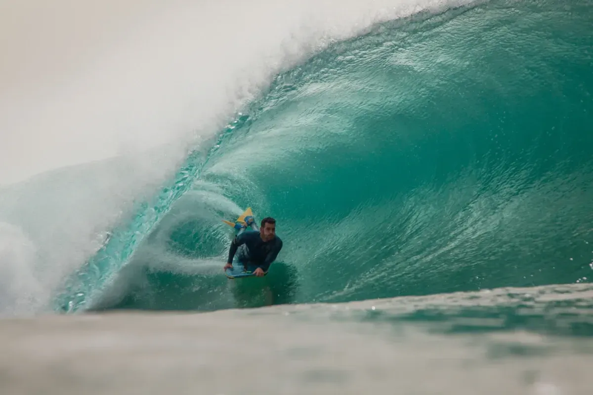 Un hombre está montando una ola en una tabla de surf en el océano.