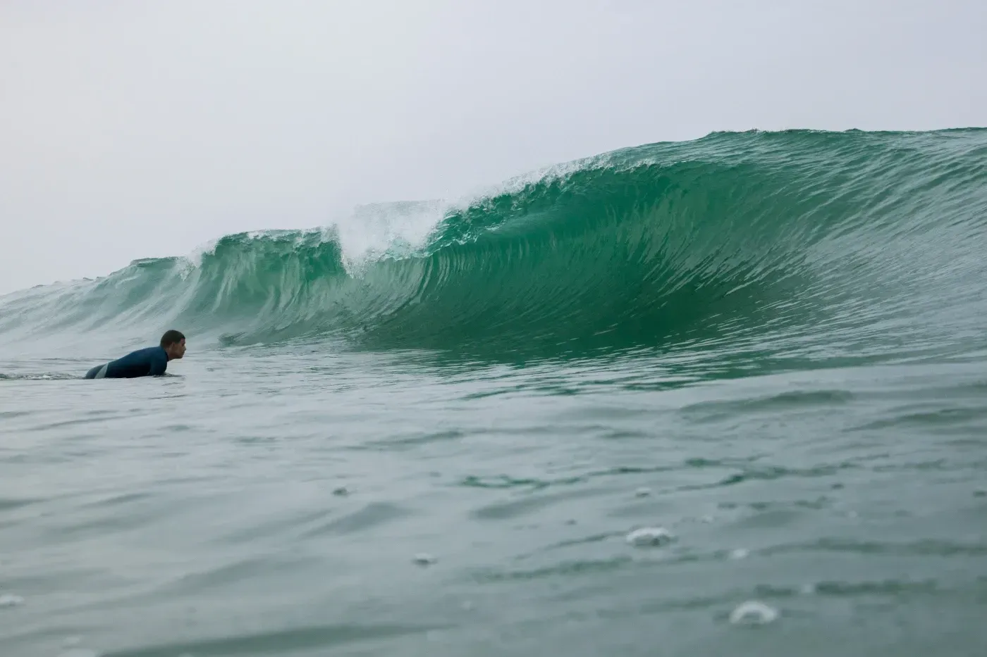 Un hombre está montando una ola en una tabla de surf en el océano.