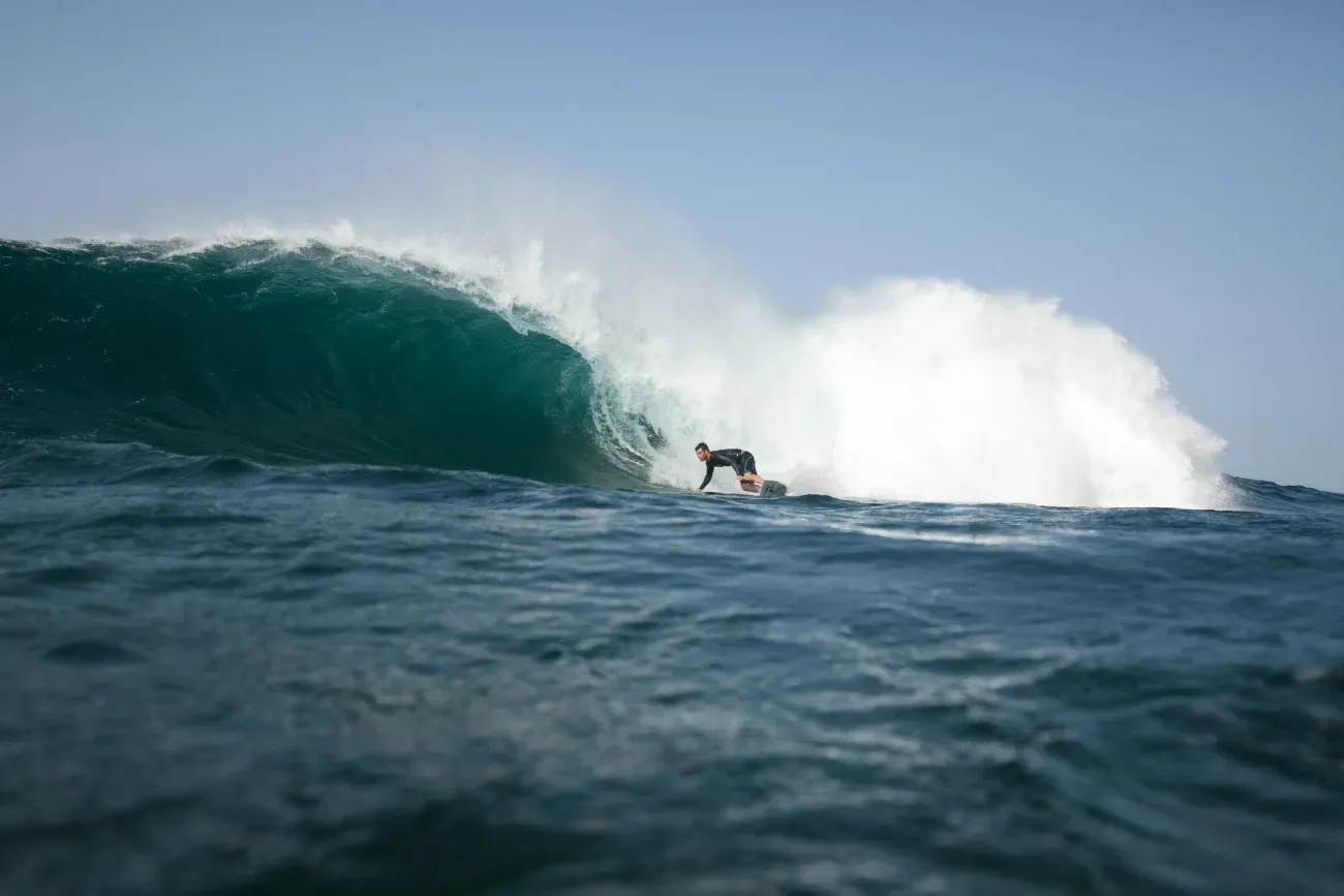 Un surfista está montando una ola en el océano.