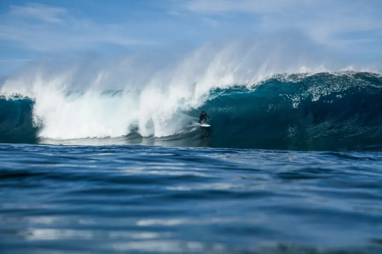 Un surfista está montando una ola en el océano.