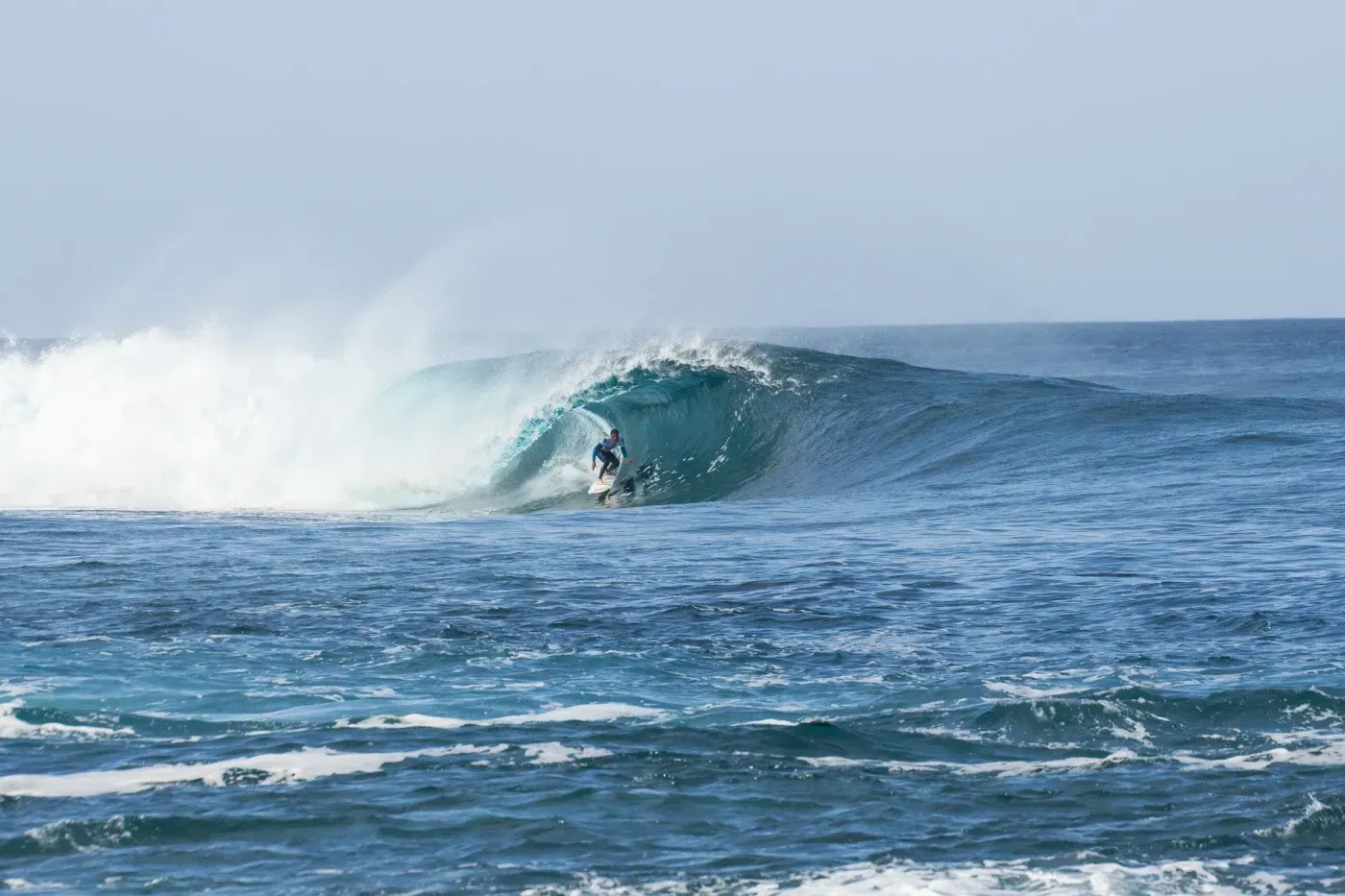 Un surfista está montando una ola en el océano.