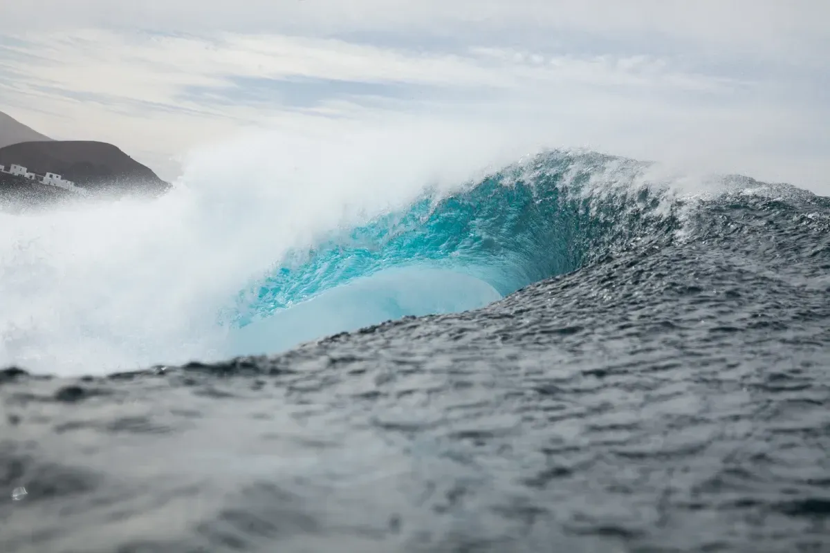 Una gran ola se estrella en una orilla rocosa del océano.