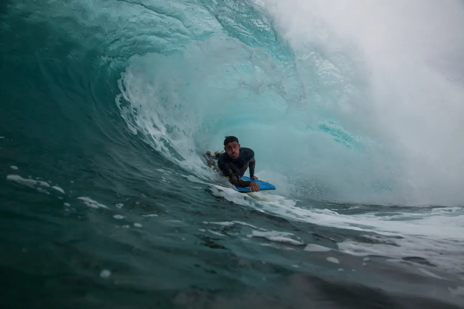 Un hombre está montando una ola en una tabla de surf en el océano.
