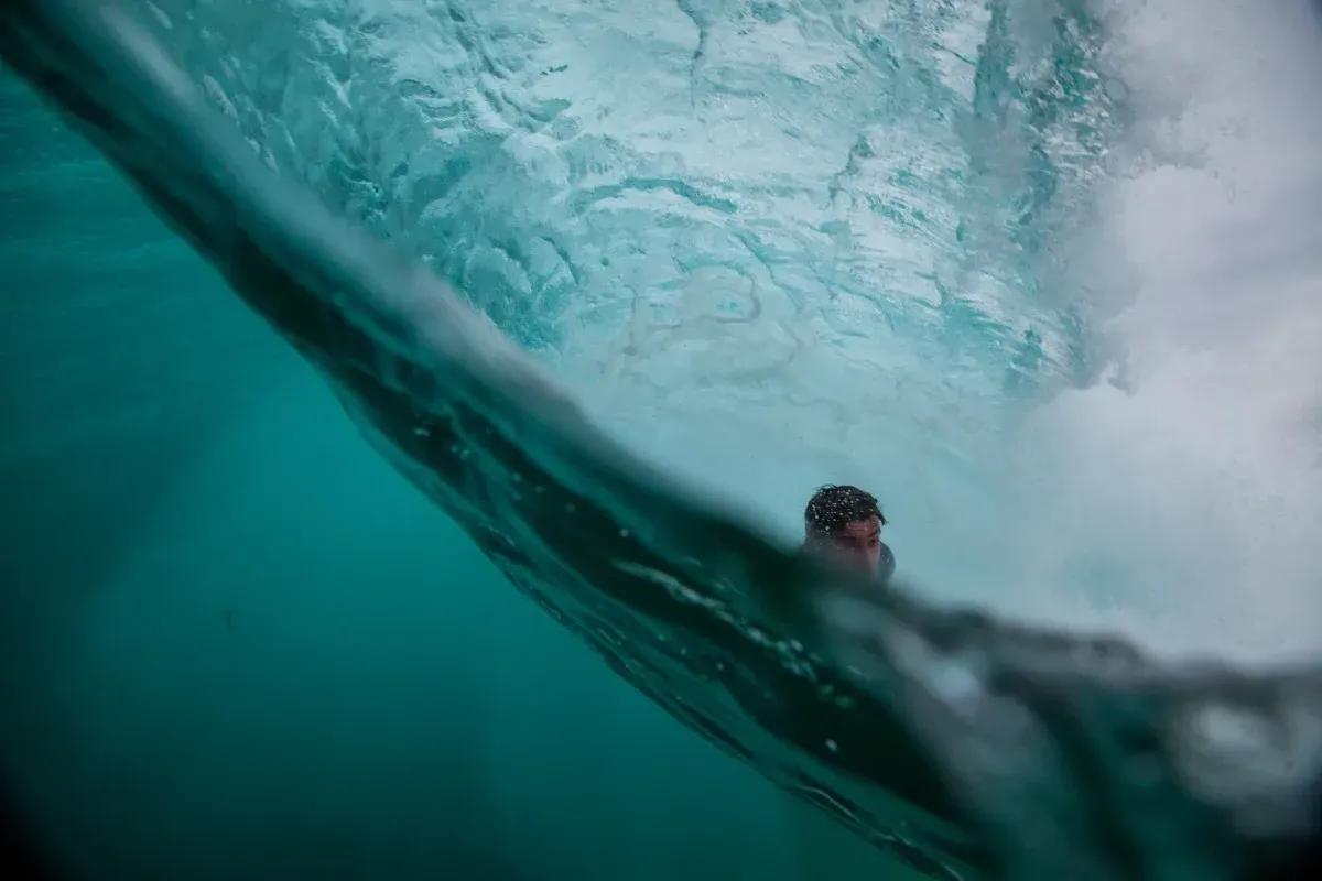 Una persona está montando una ola en el océano.