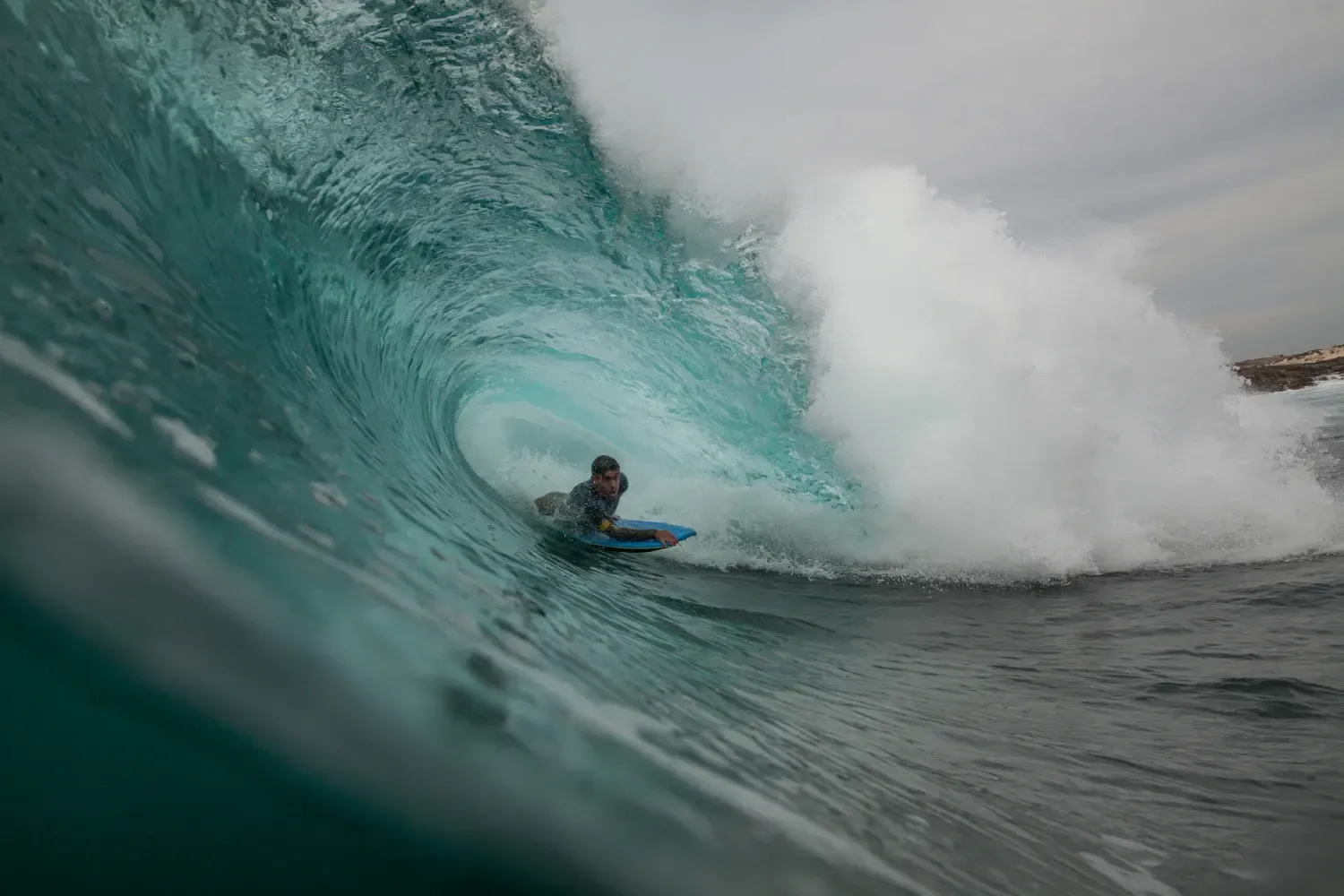 Un hombre está montando una ola en una tabla de surf en el océano.