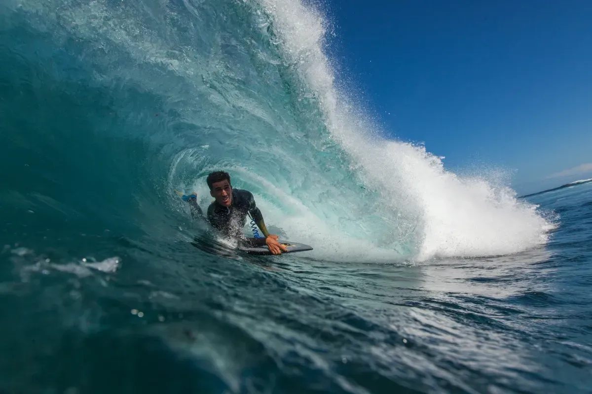 Un hombre está montando una ola en una tabla de surf en el océano.
