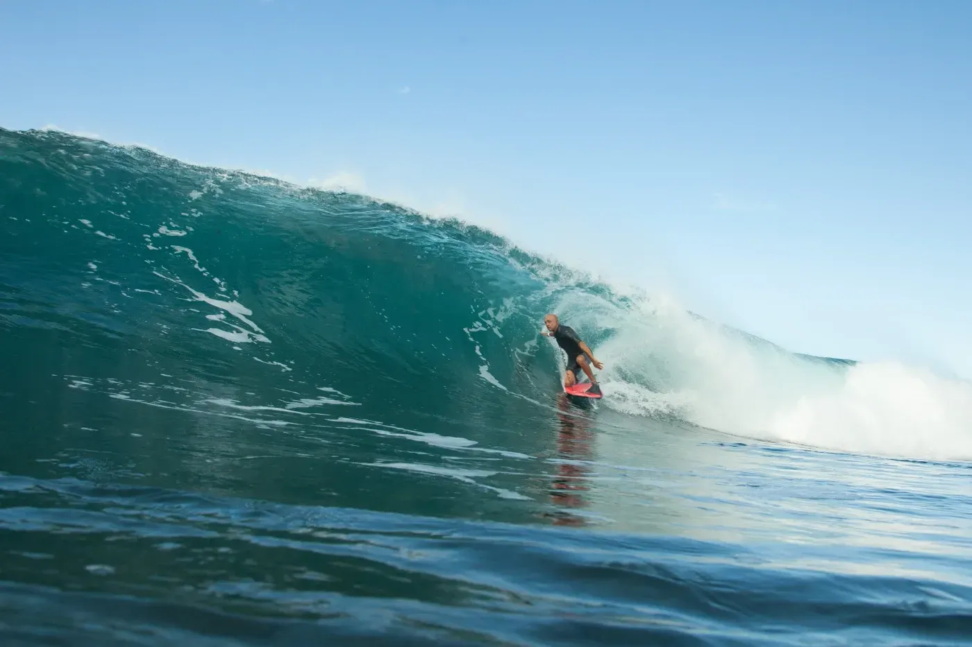 Una persona está montando una ola en una tabla de surf en el océano.