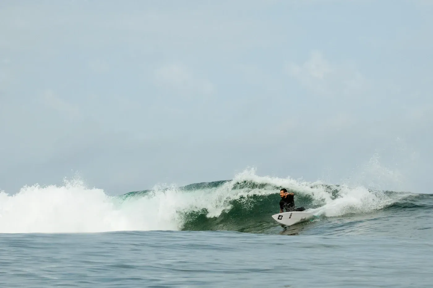 Un hombre está montando una ola en una tabla de surf en el océano.