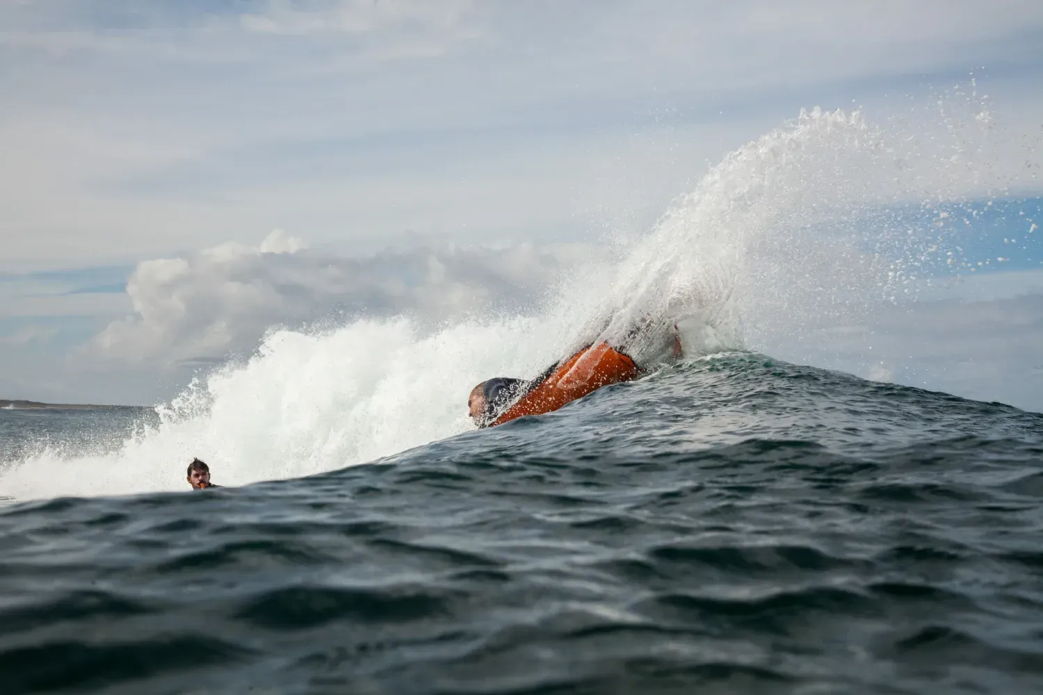 Una persona está montando una ola en el océano.