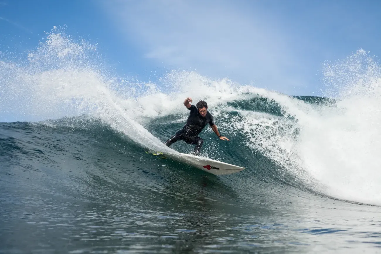 Un hombre está montando una ola en una tabla de surf en el océano.