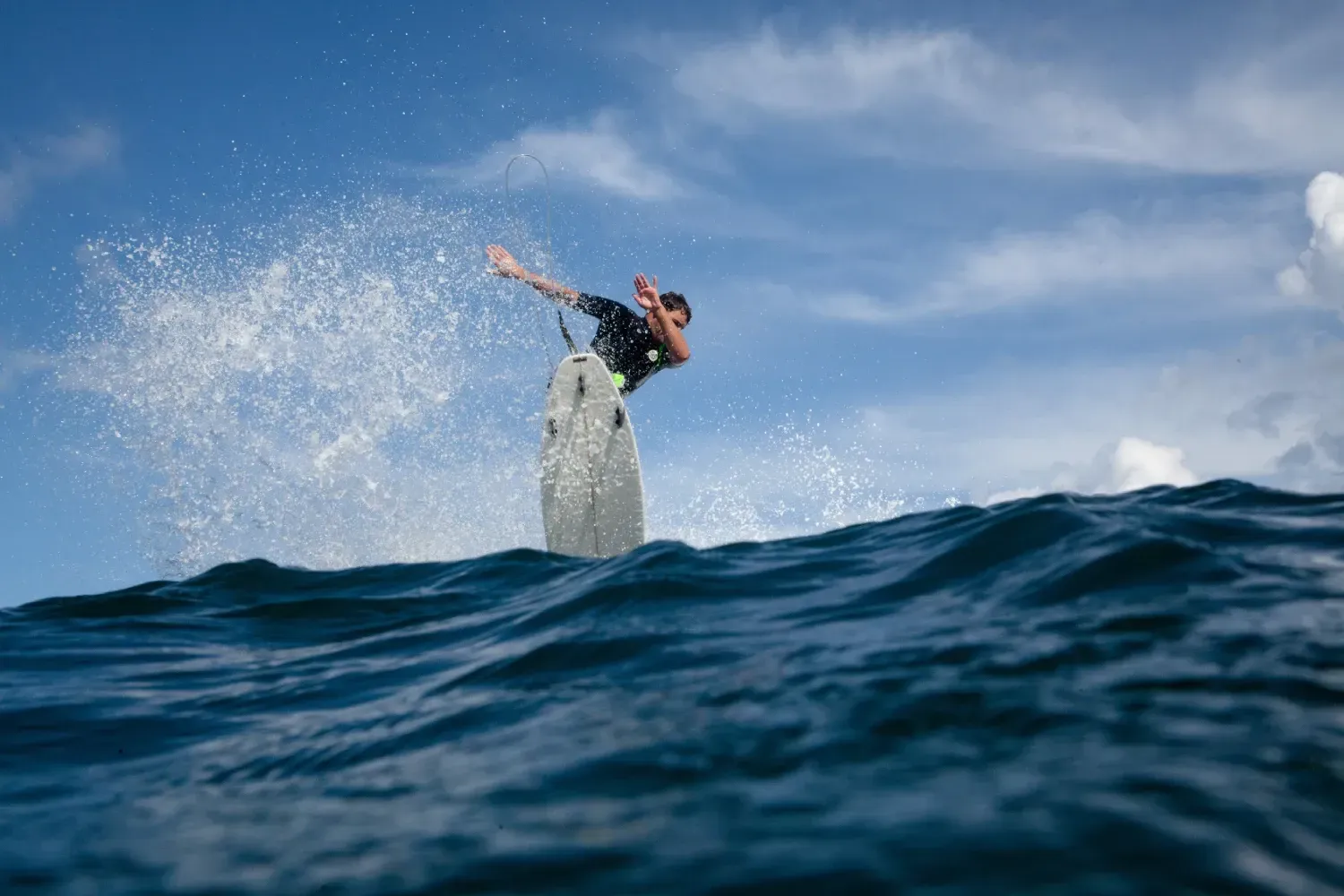 Un hombre está montando una ola en una tabla de surf en el océano.