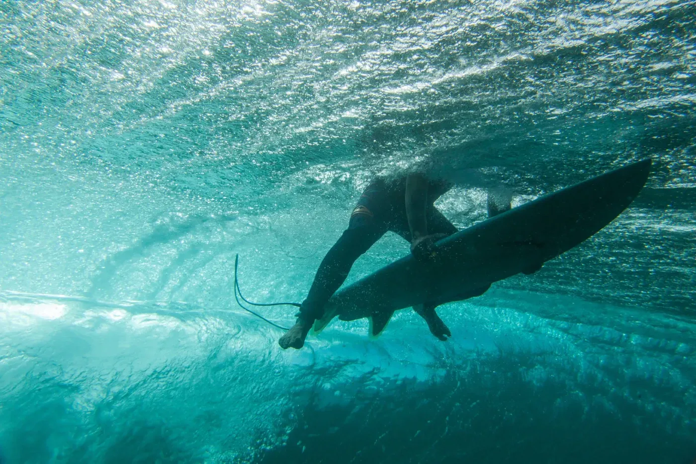 Una persona está montando una ola en una tabla de surf bajo el agua.