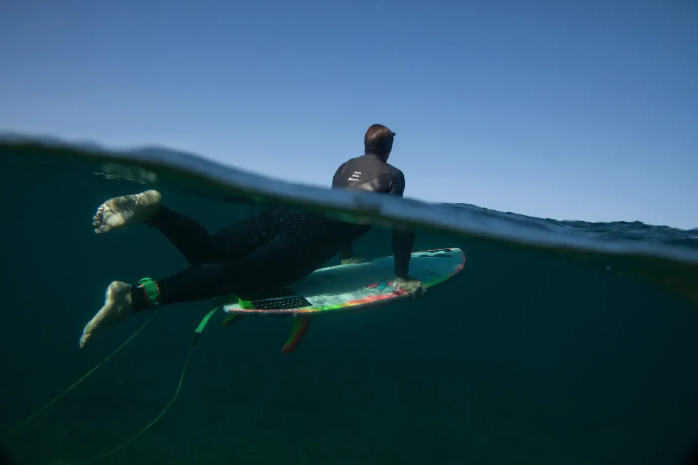 Un hombre está montando una tabla de surf en el océano.