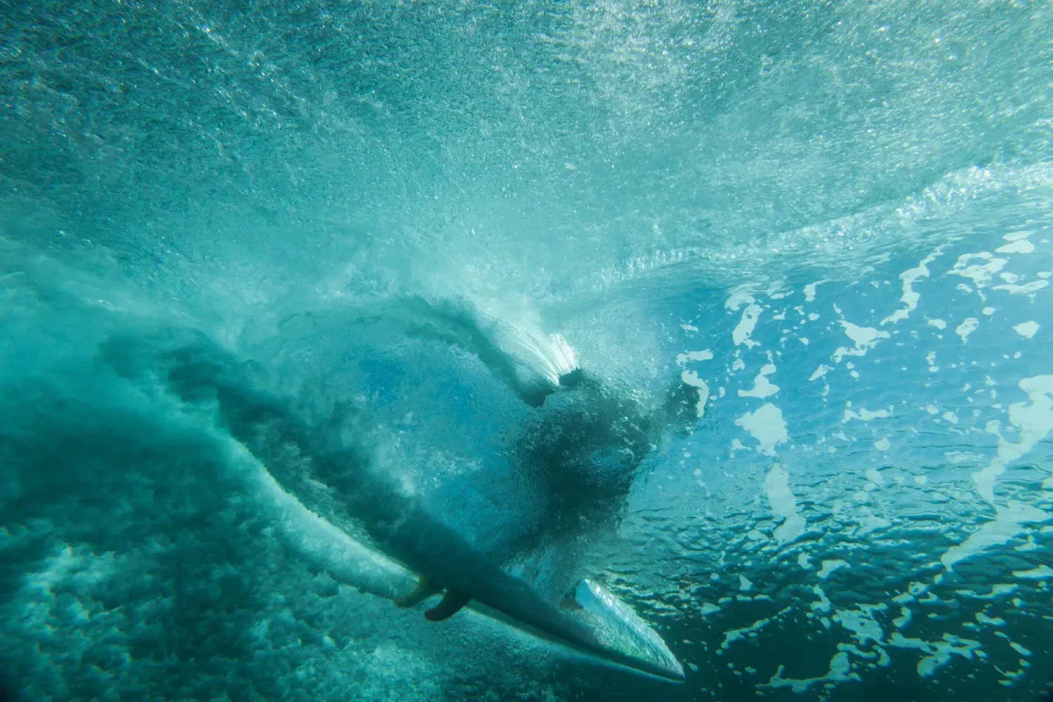 Una persona está montando una ola en una tabla de surf en el océano.