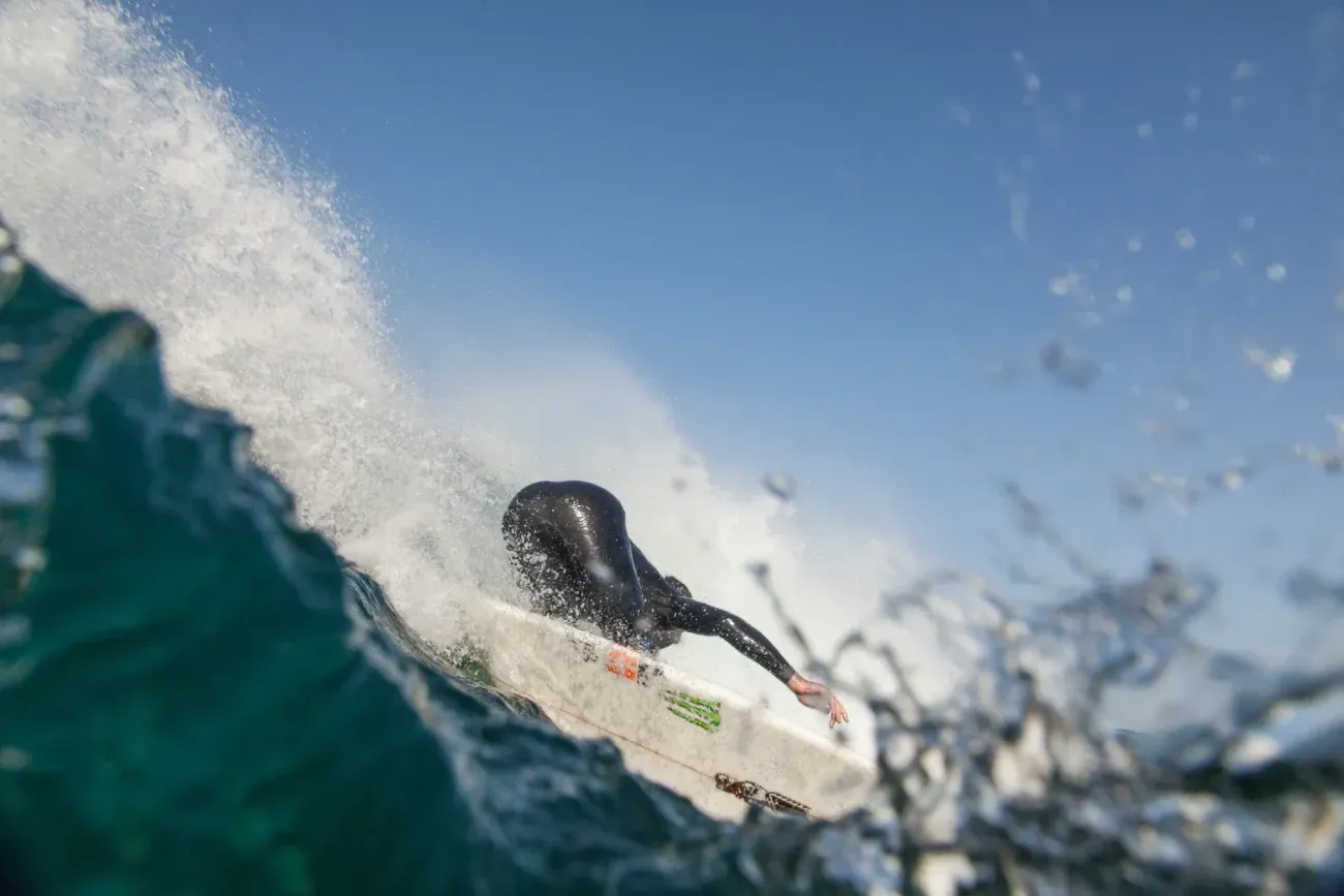 Una persona está montando una ola en una tabla de surf en el océano.