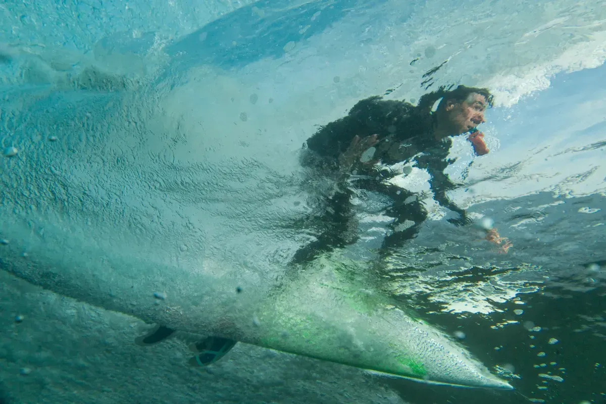 Un hombre está surfeando una ola en una tabla de surf bajo el agua.
