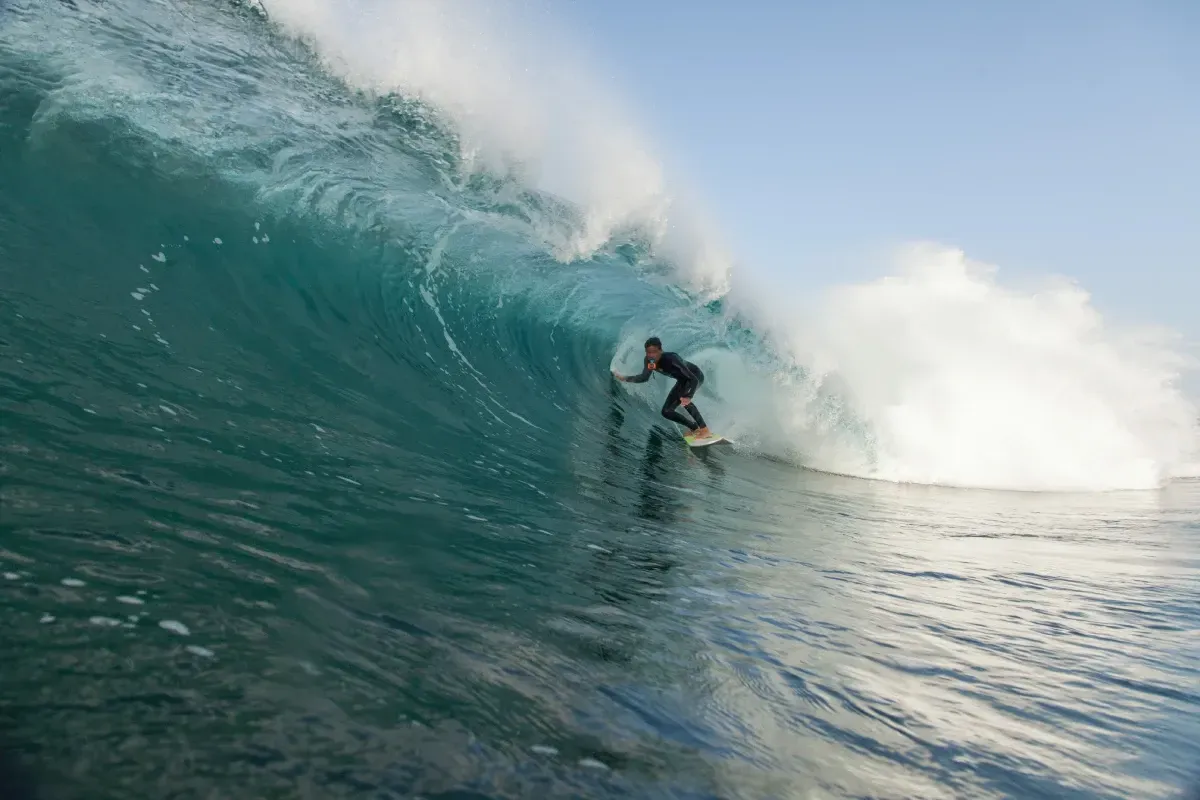 Un hombre está montando una ola en una tabla de surf en el océano.