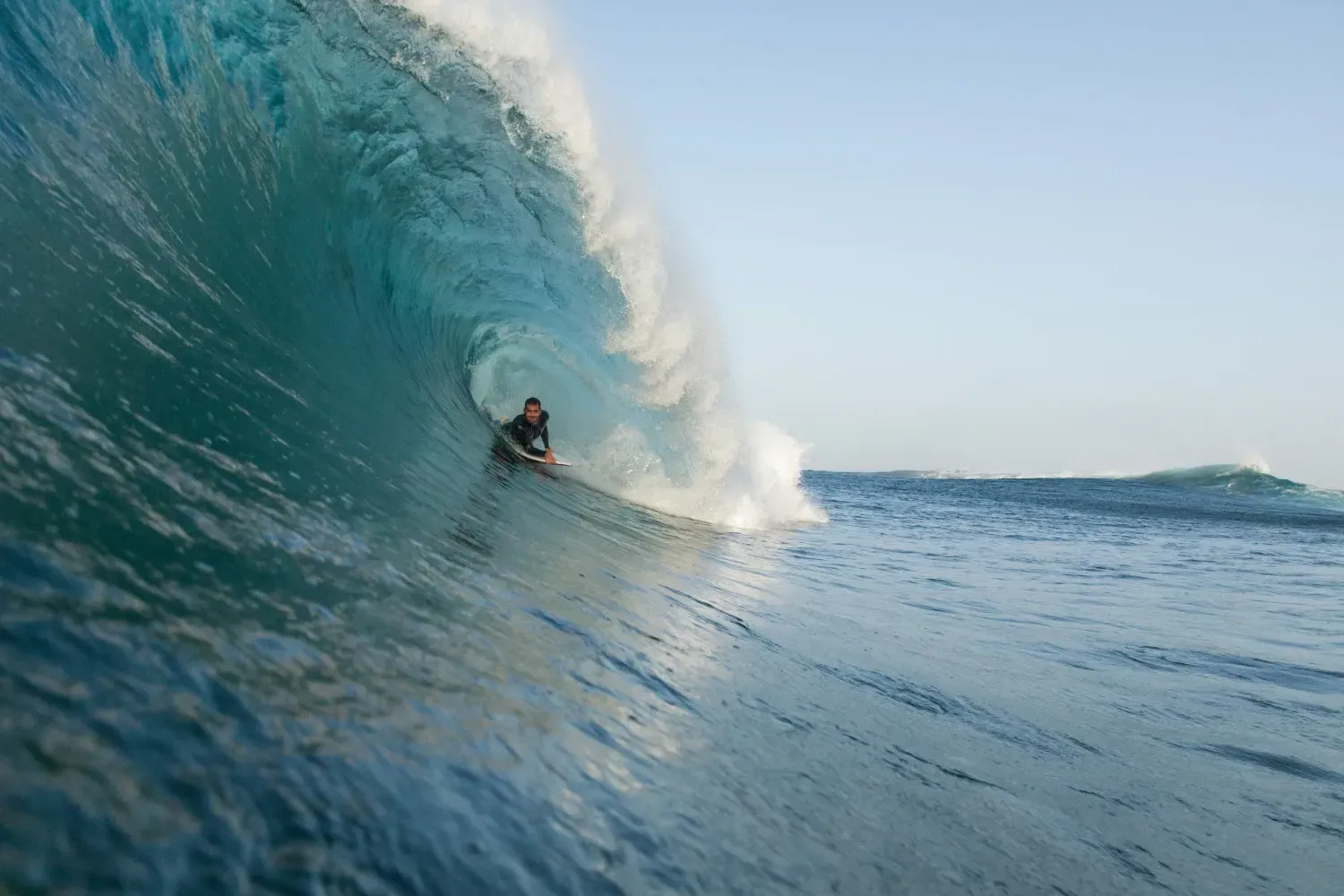Un hombre está montando una ola en una tabla de surf en el océano.