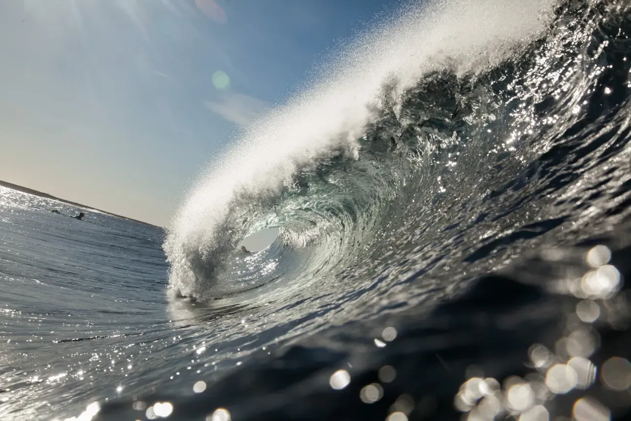 Un primer plano de una ola en el océano en un día soleado.