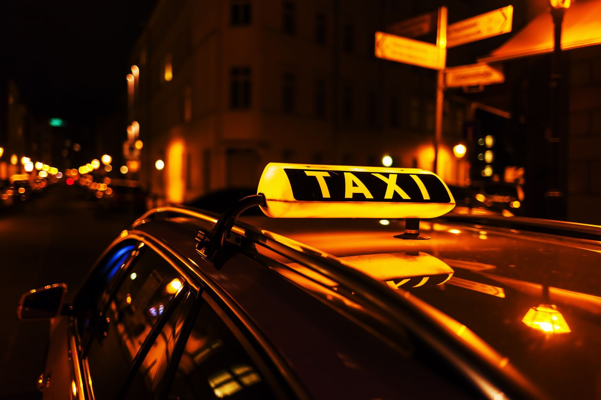 Taxi jaune de nuit dans une rue de la ville, avec des lumières scintillantes et une circulation floue en arrière-plan