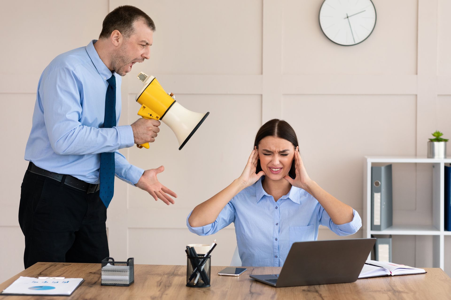 Un homme hurle sur une femme avec un mégaphone.