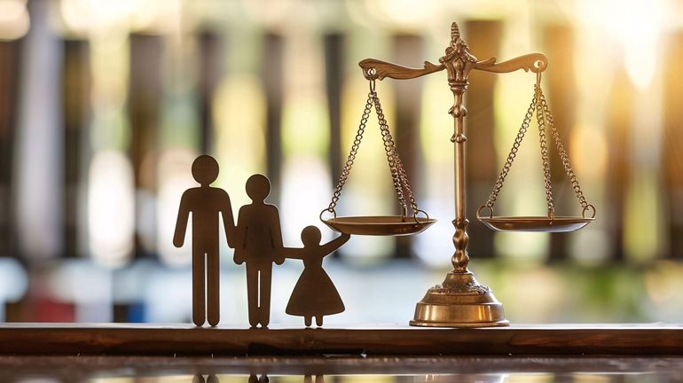 Une maquette de famille à côté d'une balance.