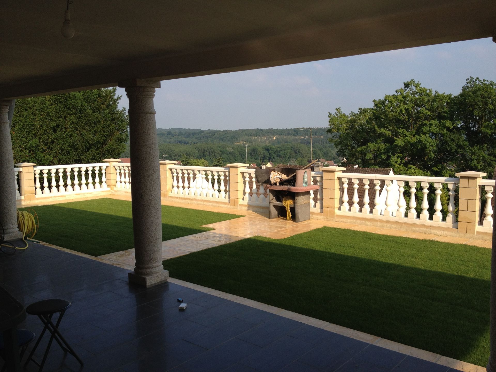 Engazonnement devant terrasse avec barbecue en pierre