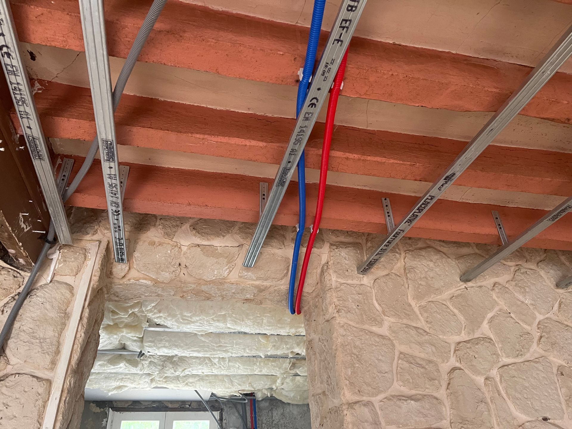 Passage des gaines d'eau chaude et froide dans un plafond