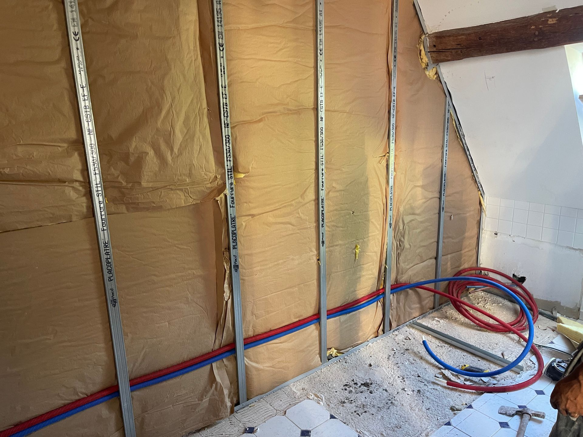 Pose d'isolant et passage de gaine avant les plaques